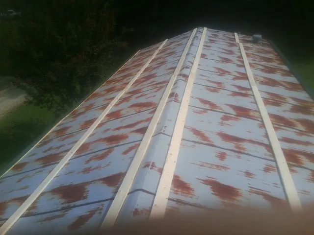 Rusted metal roof panels with new wood purlins before replacement — Storm Damage Roof Repair in Middlesboro by Roofing Brothers