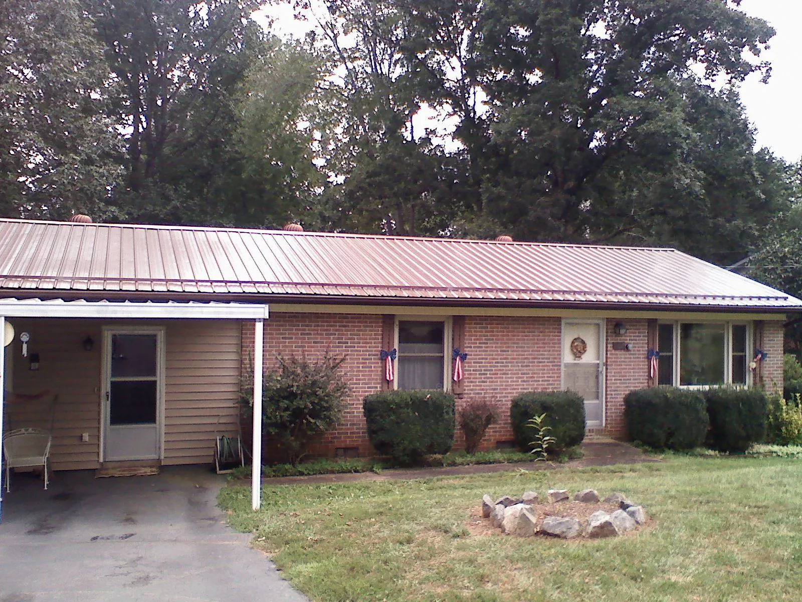 Bronze metal roof and carport on a brick ranch home — Roof Repair work by our crew in Middlesboro